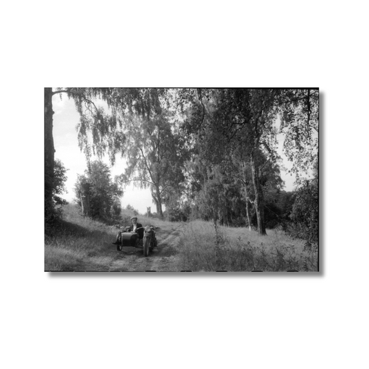 Uldis Brauns. Postcard, Akniste Townscape. A motorcycle with sidecar and a truck on the street.